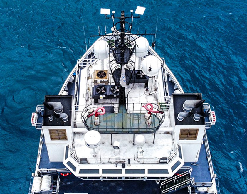 Maritime vessel equipped with multiple Starlink antennas traversing deep blue waters.